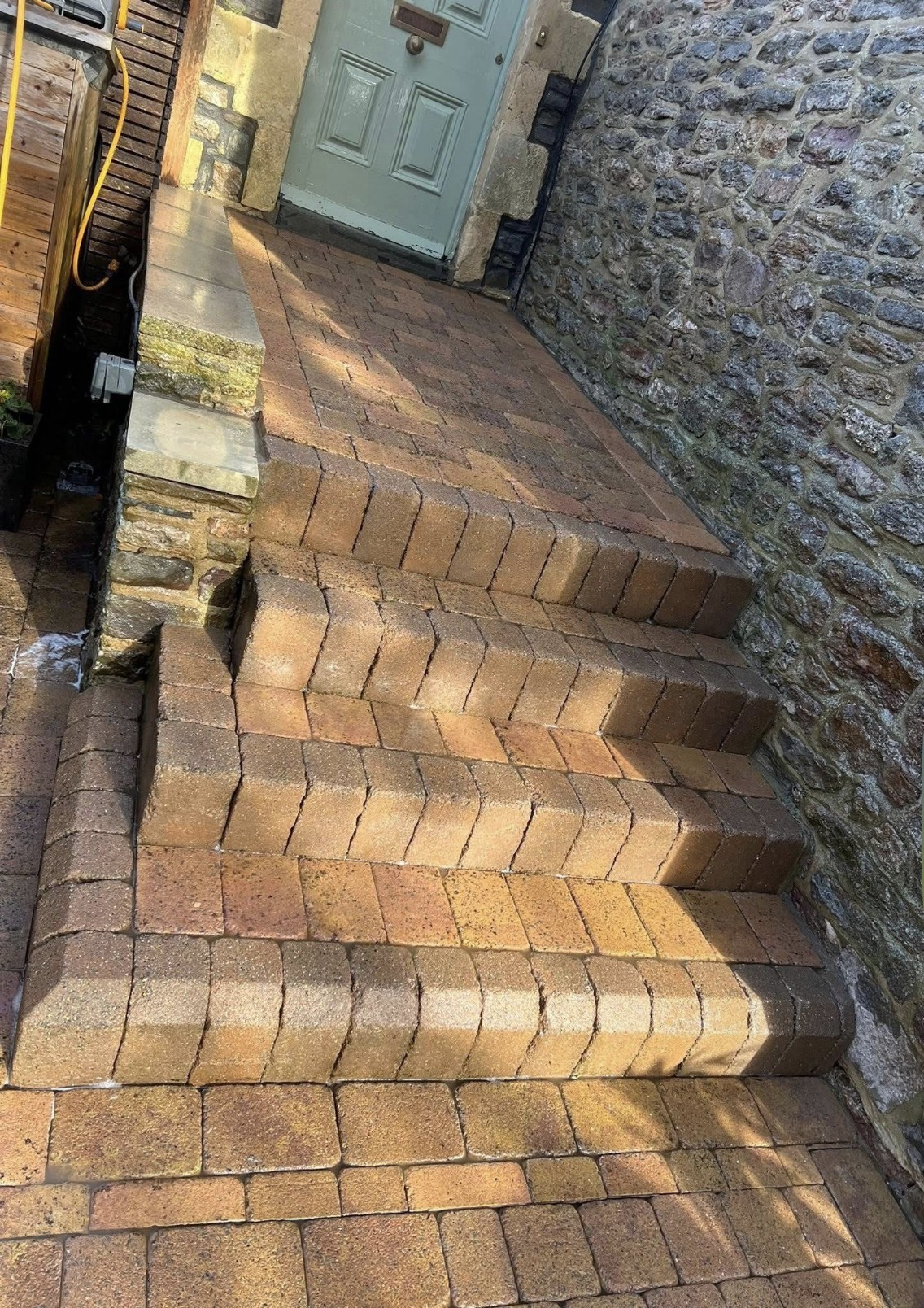 Freshly cleaned brick steps and pathway at a stone cottage