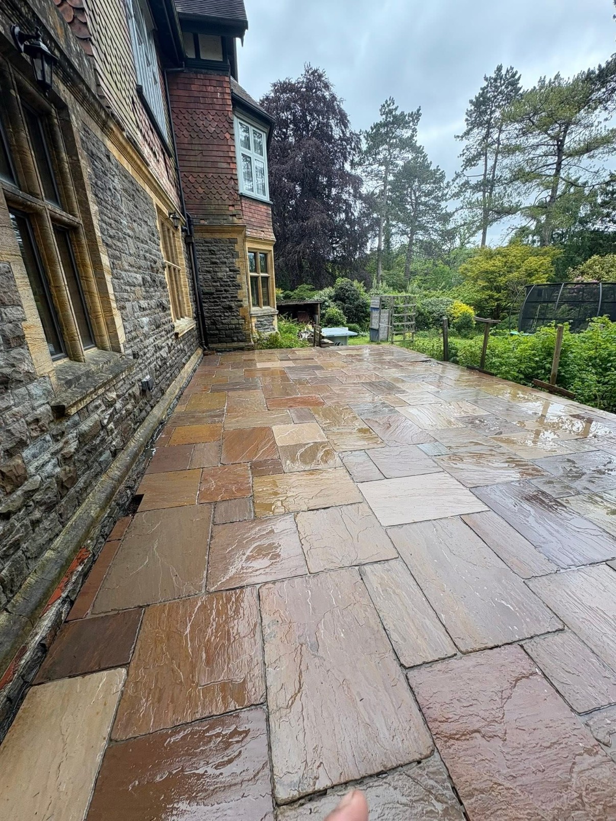 Freshly cleaned sandstone patio at a period stone house, restored to its natural colour variation